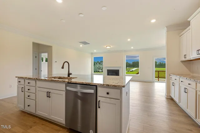 a kitchen with stainless steel appliances granite countertop a sink and cabinets with wooden floor