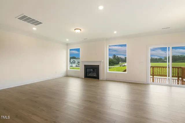 an empty room with wooden floor and fireplace