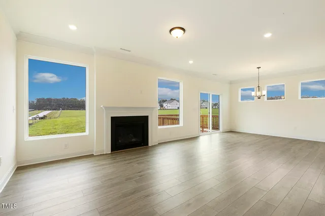 an empty room with wooden floor and a fireplace