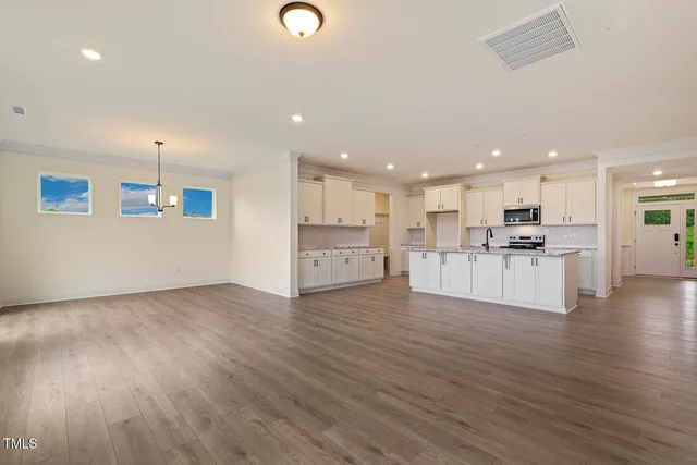 a view of kitchen with kitchen island wooden floor and center island