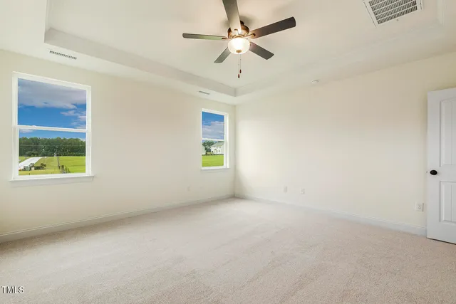 an empty room with a window and a fan