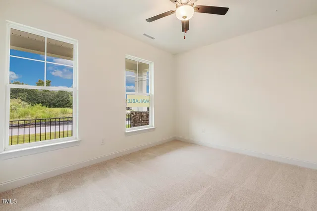an empty room with chandelier fan