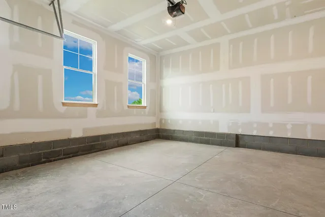 an empty room with a refrigerator and wooden floor