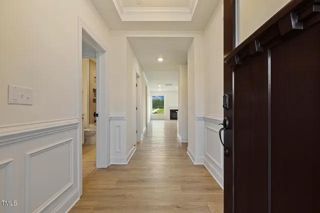 a view of a hallway with wooden floor and staircase