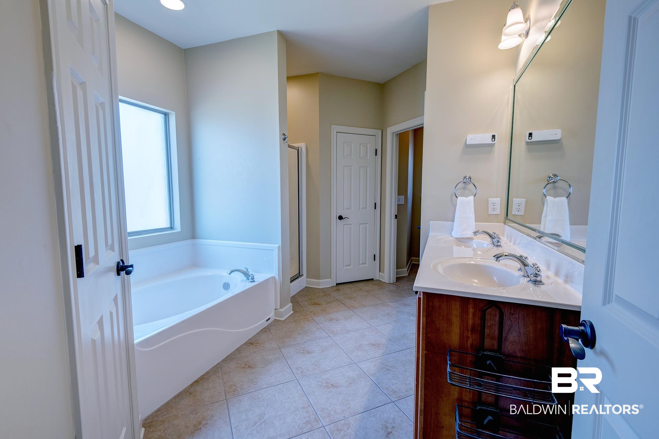 9421 Collier Loop Daphne, AL 36526 - Photo 24 of 31 Bathroom featuring a bath, double vanity, light tile patterned floors, and a stall shower