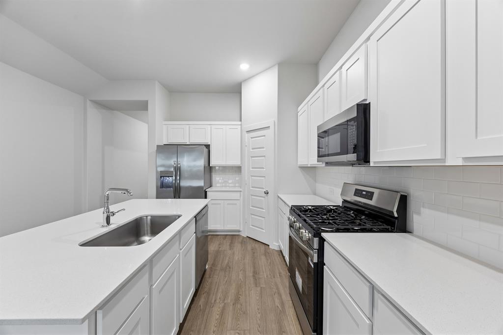 1322 Capecastle Lane Forney, TX 75126 - Photo 7 of 31 a kitchen that has a sink and a stove top oven