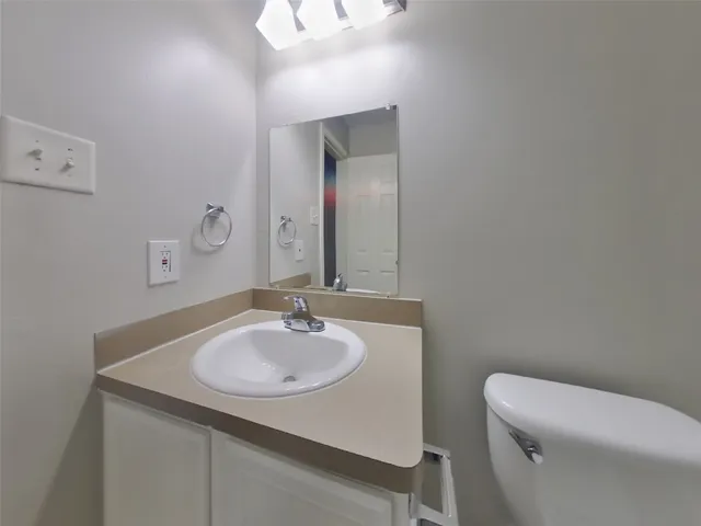 a bathroom with a toilet sink and mirror