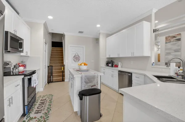 a kitchen with granite countertop a sink stove and refrigerator