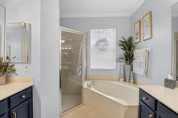 a bathroom with a tub a sink and a window