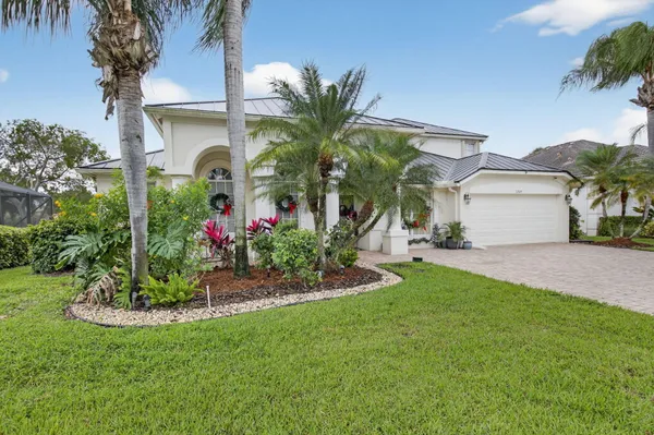 a view of a house with a yard and potted plants