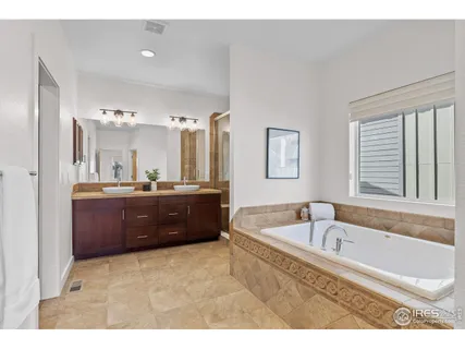 a bathroom with a tub a sink and mirror