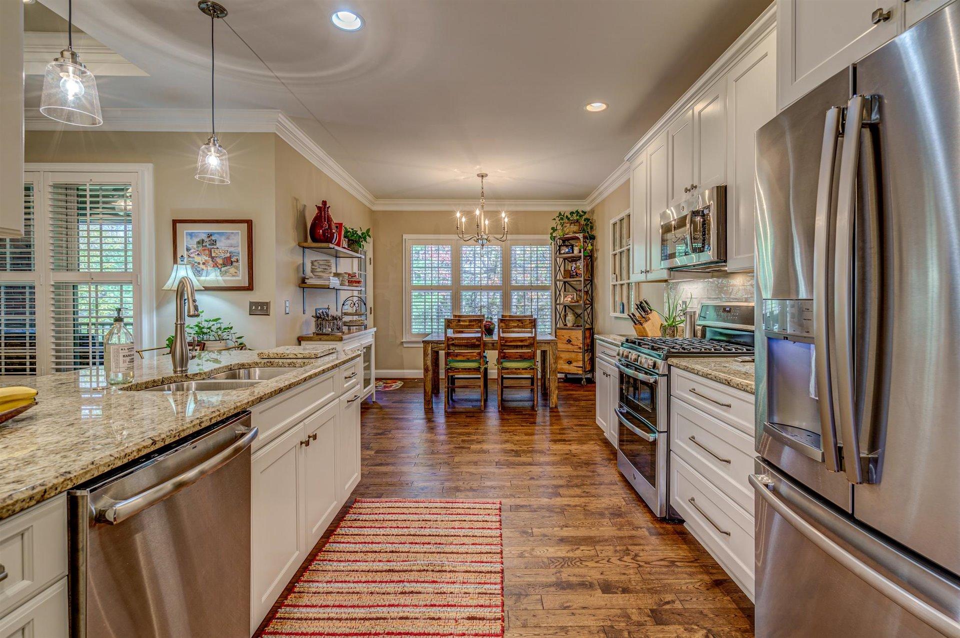 6989 Fairway Ridge Road Salem, VA 24153 - Photo 18 of 51 a kitchen with stainless steel appliances granite countertop a refrigerator a sink dishwasher a dining table and chairs with wooden floor