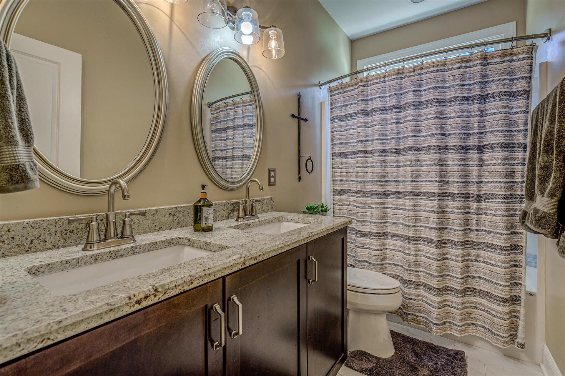 6989 Fairway Ridge Road Salem, VA 24153 - Photo 34 of 51 a bathroom with a granite countertop toilet a sink and a mirror
