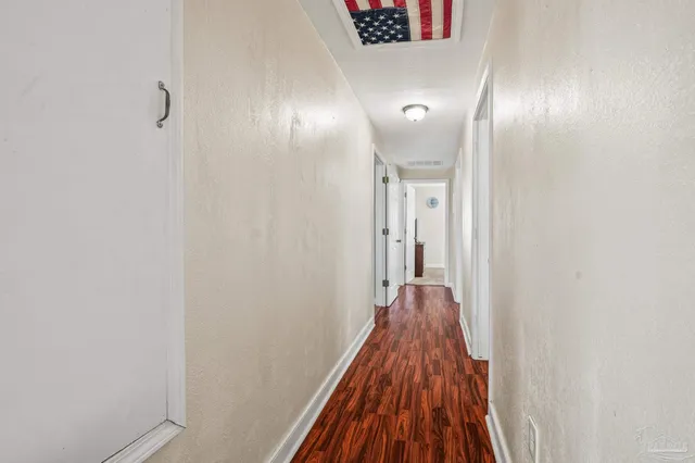 a view of a room with wooden floor and a hallway