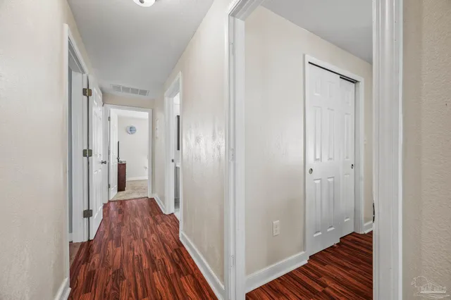 a view of a hallway with wooden floor and closet