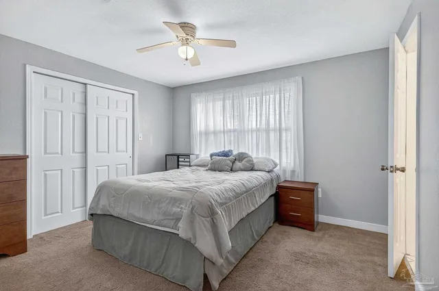 a large bed sitting in a bedroom next to a window and a chandelier