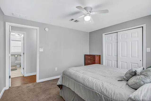 a spacious bedroom with a bed and a chandelier