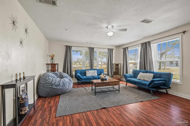 a living room with furniture and a wooden floor