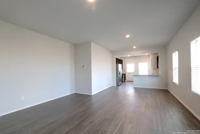 a view of empty room with wooden floor and window