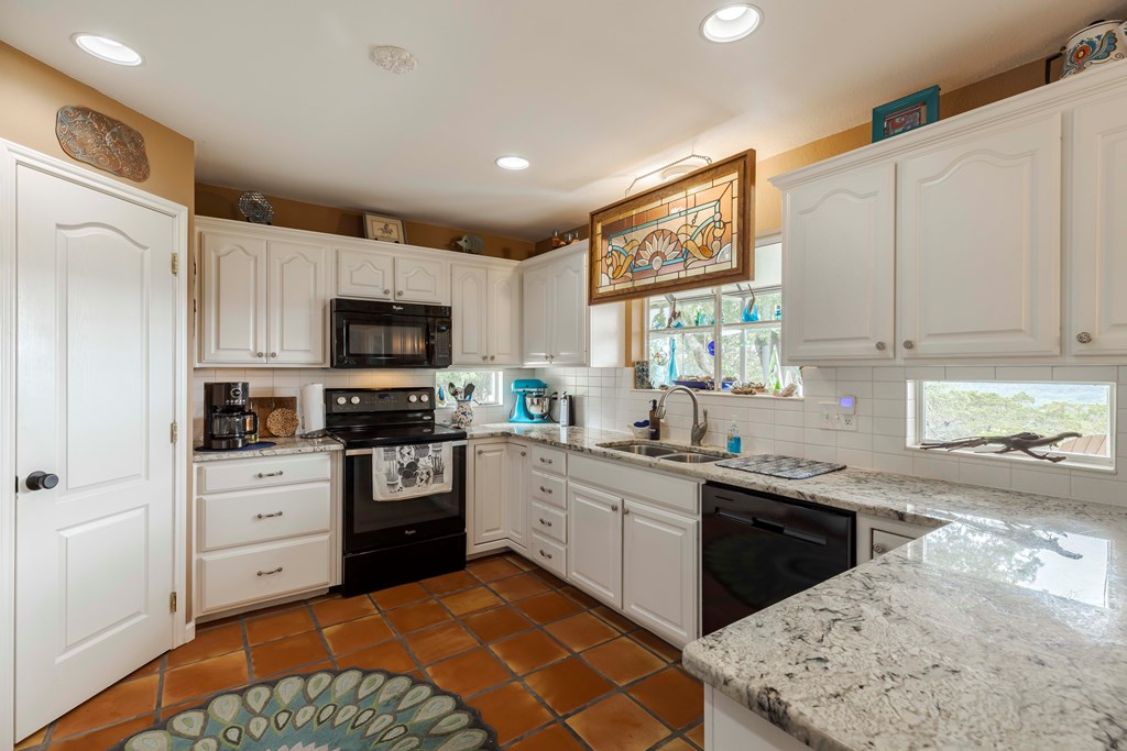 116 Ridge Road West Ingram, TX 78025 - Photo 15 of 65 a kitchen with stainless steel appliances granite countertop white cabinets sink and window