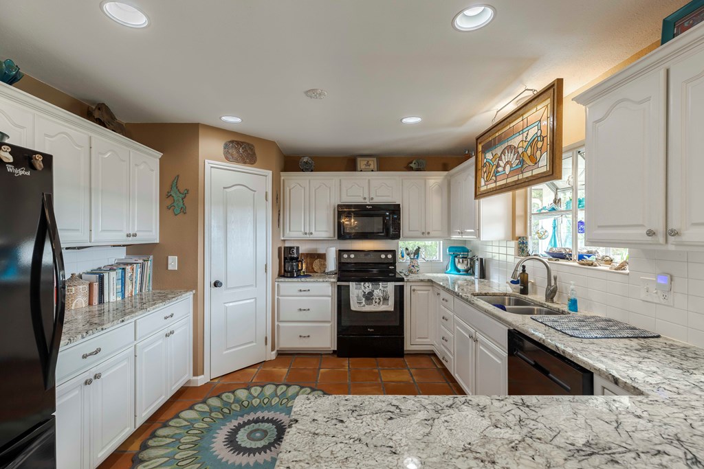 116 Ridge Road West Ingram, TX 78025 - Photo 17 of 65 a kitchen with stainless steel appliances granite countertop a stove top oven a sink and a refrigerator