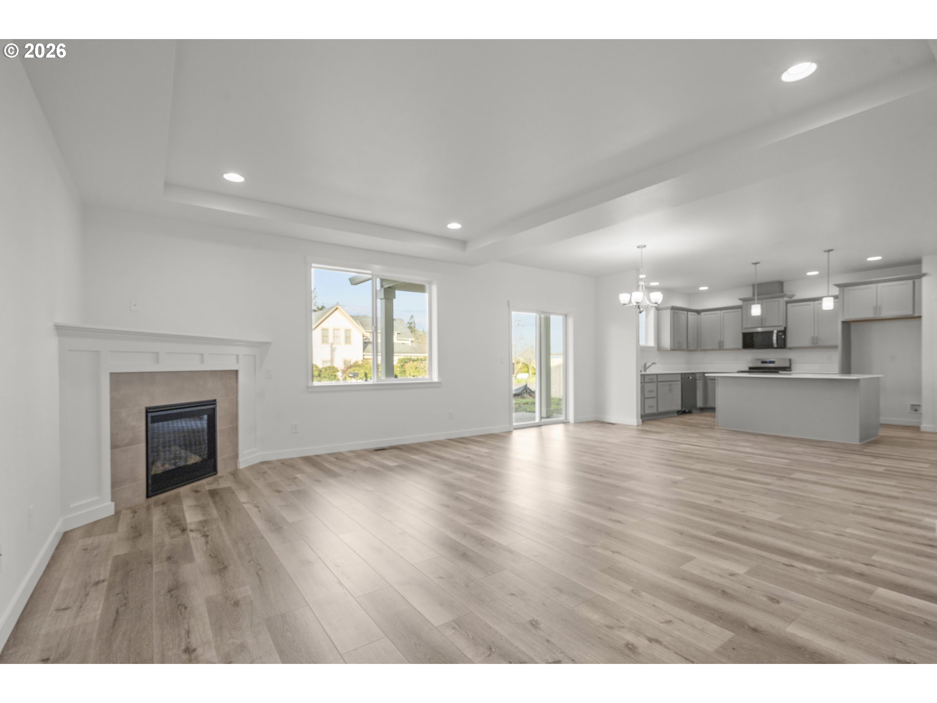 673 Parker Loop Silverton, OR 97381 - Photo 9 of 37 a view of an empty room and a kitchen with wooden floor