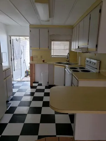 a kitchen with a refrigerator and a stove