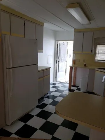 a kitchen with a refrigerator and a stove top oven