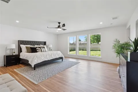 a bedroom with a large bed and a potted plant