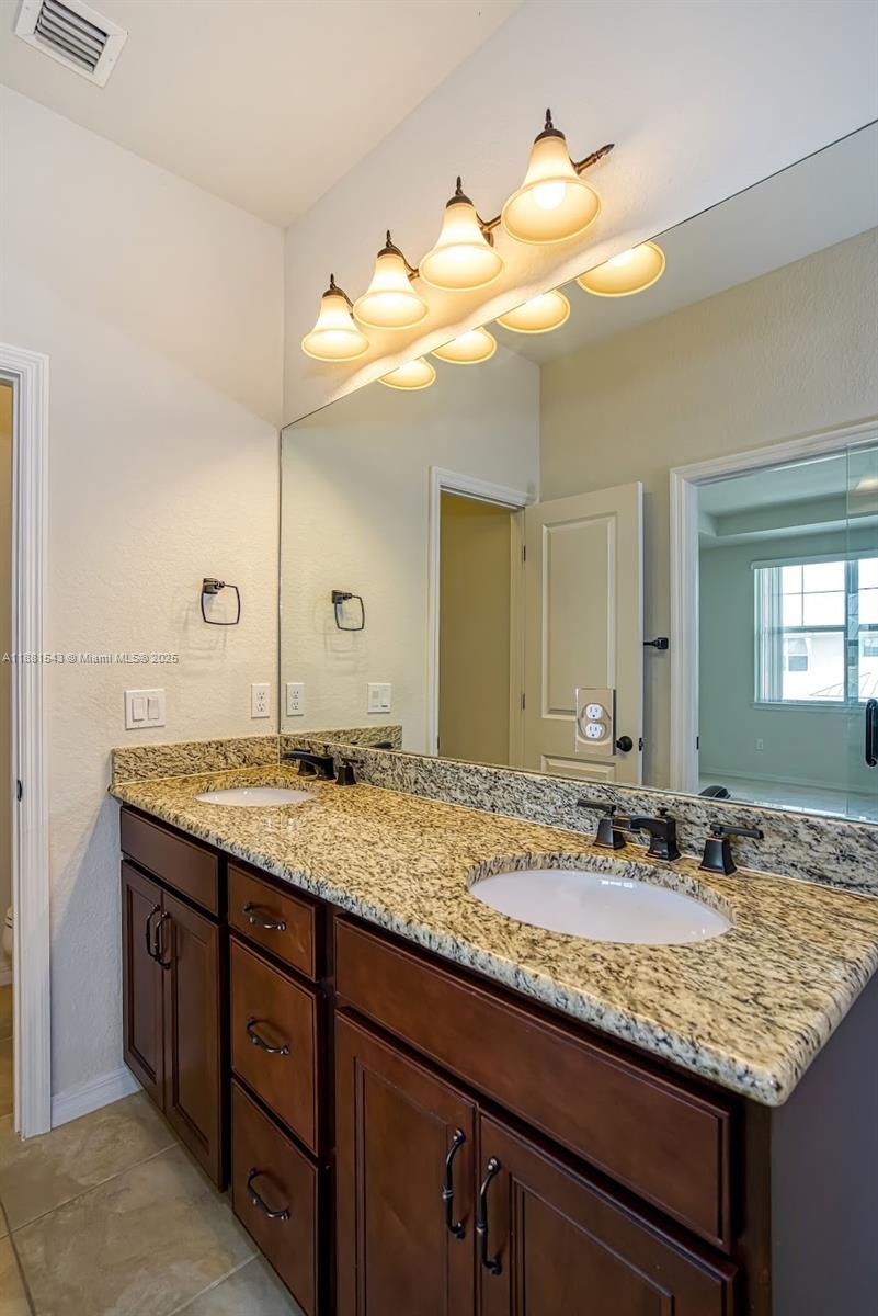 5060 Eucalyptus Drive, Unit 2 Hollywood, FL 33021 - Photo 27 of 43 a bathroom with a granite countertop sink and a mirror