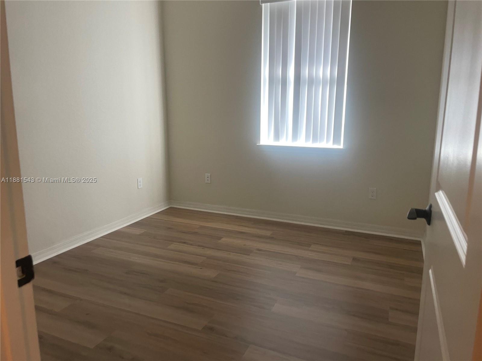 5060 Eucalyptus Drive, Unit 2 Hollywood, FL 33021 - Photo 37 of 43 an empty room with wooden floor and windows