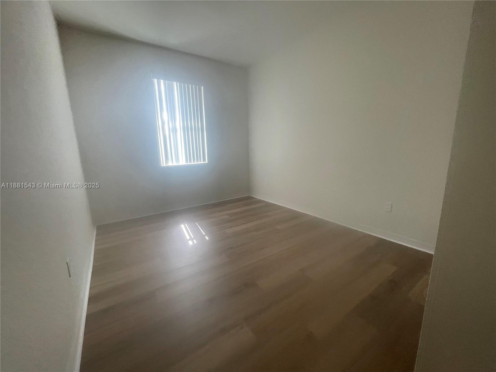 5060 Eucalyptus Drive, Unit 2 Hollywood, FL 33021 - Photo 38 of 43 an empty room with wooden floor and windows in it