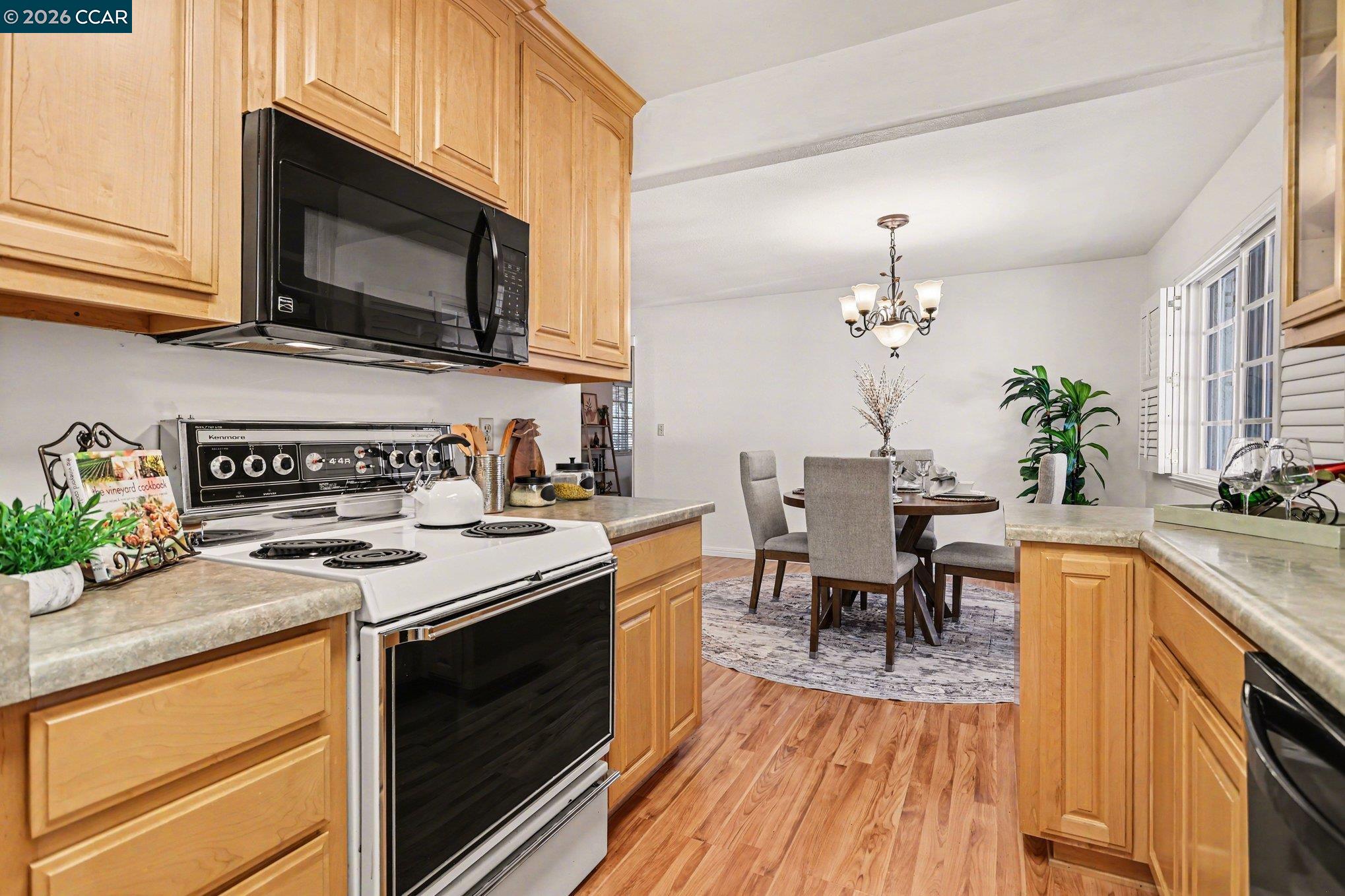 1451 Franklin Canyon Road Martinez, CA 94553 - Photo 7 of 45 a kitchen with stainless steel appliances granite countertop a stove top oven a sink dishwasher a dining table and chairs with wooden floor