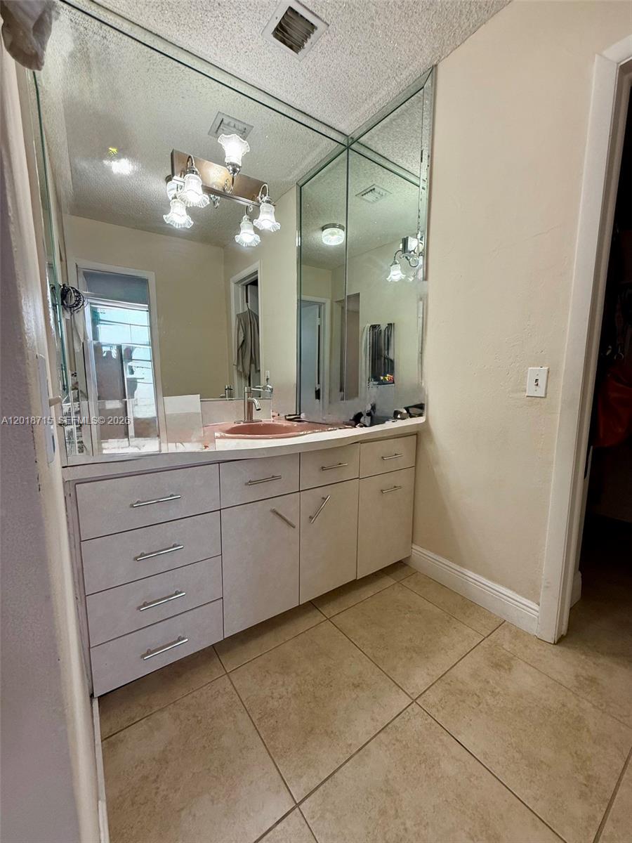6720 Southwest 21st Street, Unit 1 Miami, FL 33155 - Photo 21 of 26 a bathroom with a double vanity sink and a mirror