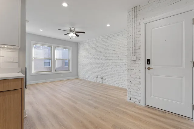 an empty room with windows and cabinet