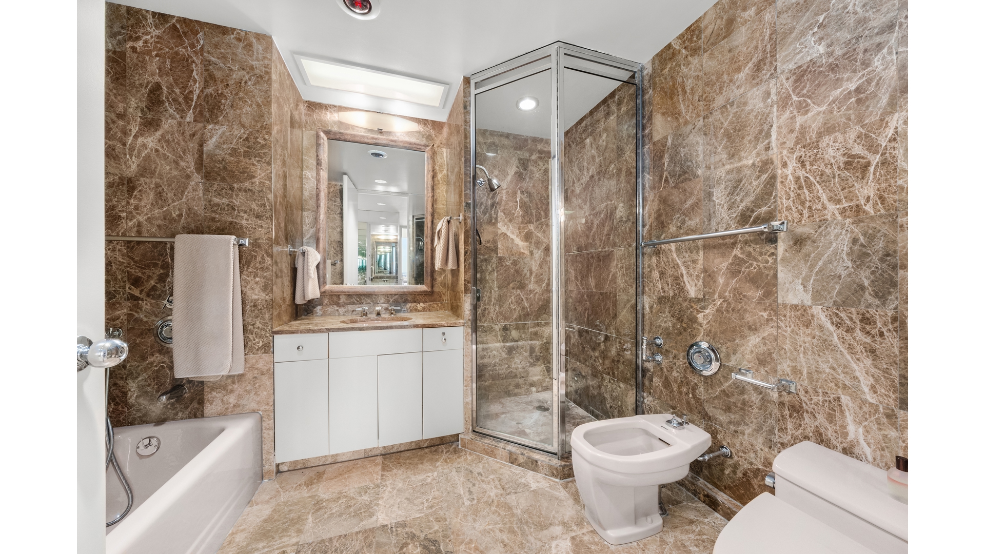 641 5th Avenue, Unit 35A Manhattan, NY 10022 - Photo 4 of 10 a bathroom with a sink toilet and shower