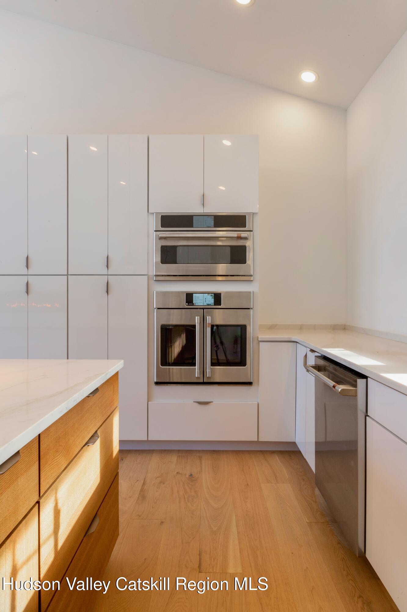 513 Myrtle Avenue Wallkill, NY 12589 - Photo 17 of 62 a kitchen with stainless steel appliances a stove a microwave and white cabinets