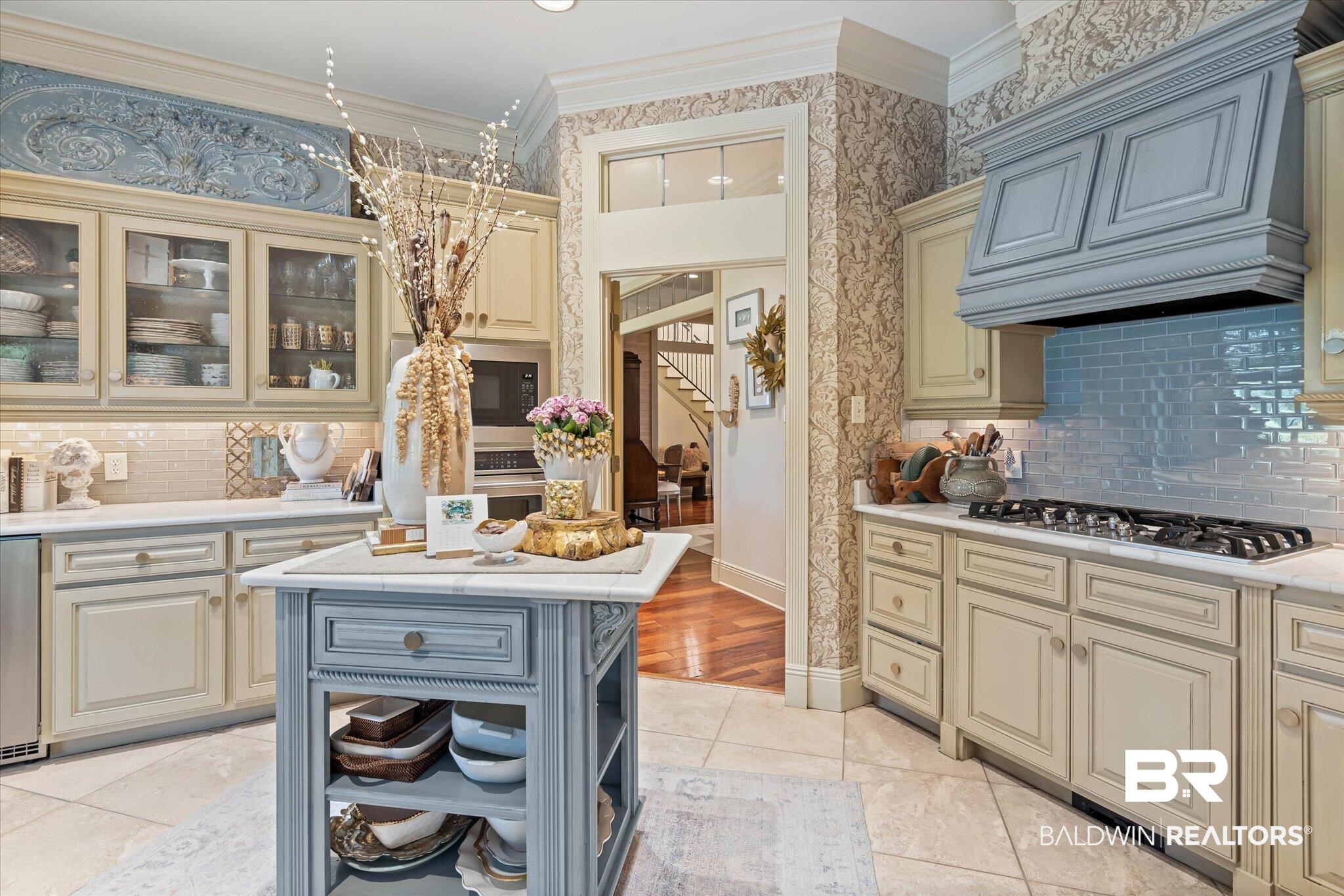 2905 Riverview Pointe Drive South Theodore, AL 36582 - Photo 11 of 44 Kitchen featuring decorative backsplash, crown molding, cream cabinetry, glass fronted cabinets, and open shelves