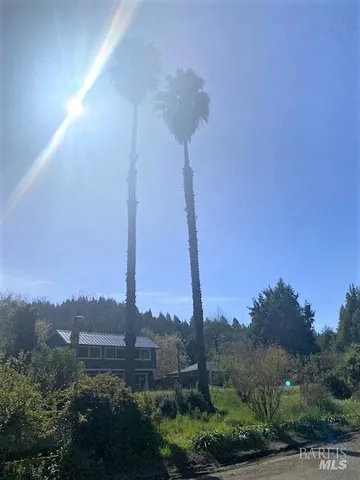 a view of a city with tall buildings and a street sign next to a road