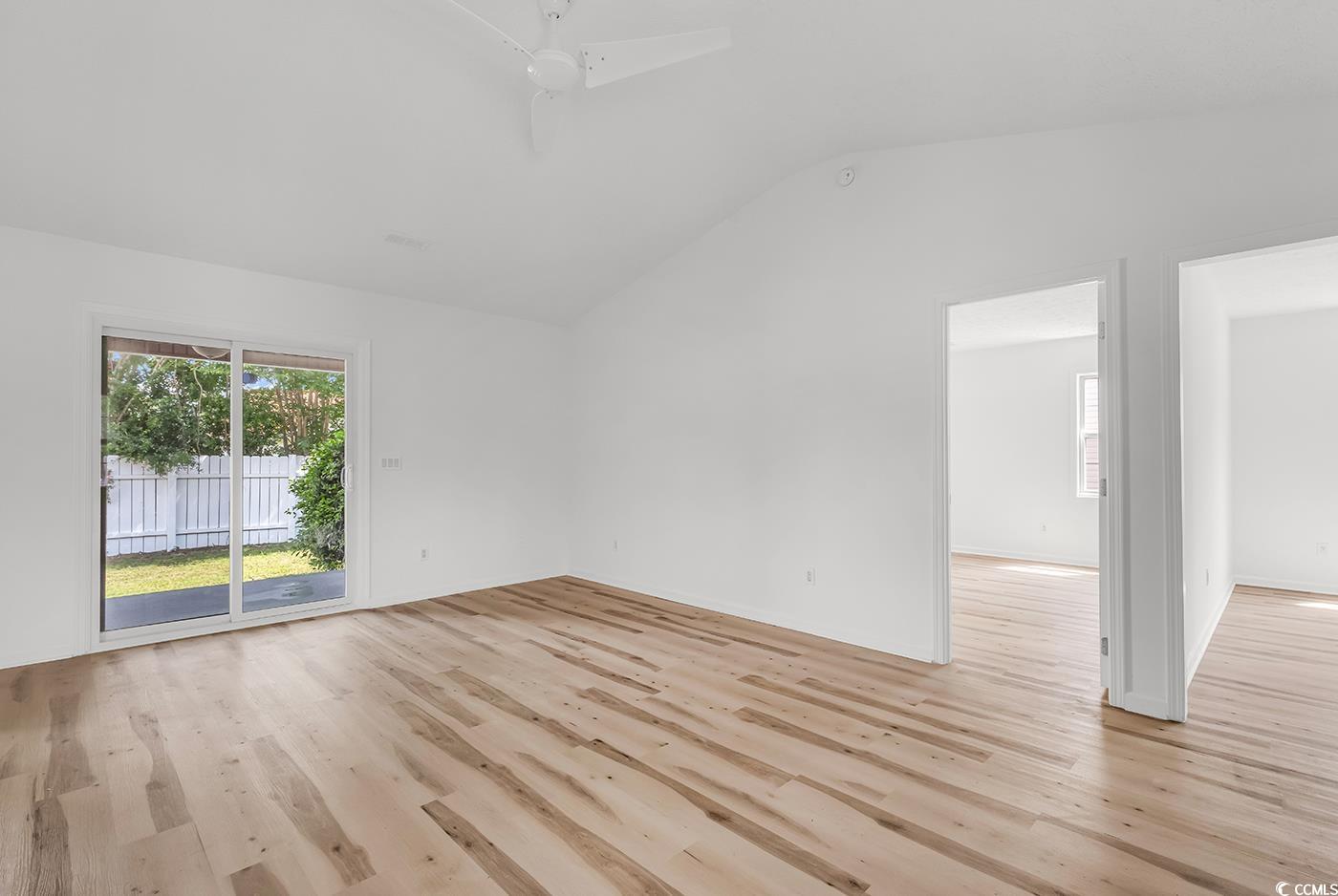 9616 Sullivan Drive Murrells Inlet, SC 29576 - Photo 7 of 23 Empty room with vaulted ceiling and light wood fin