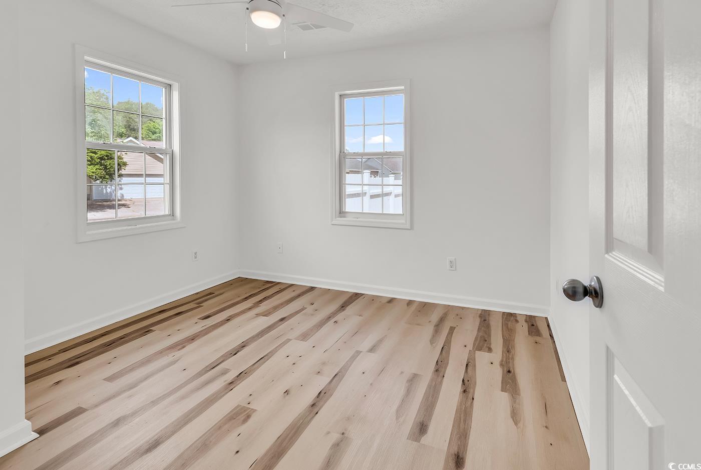 9616 Sullivan Drive Murrells Inlet, SC 29576 - Photo 9 of 23 Spare room with baseboards, ceiling fan, and wood
