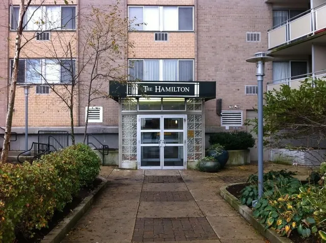 a front view of a house with a yard and potted plants