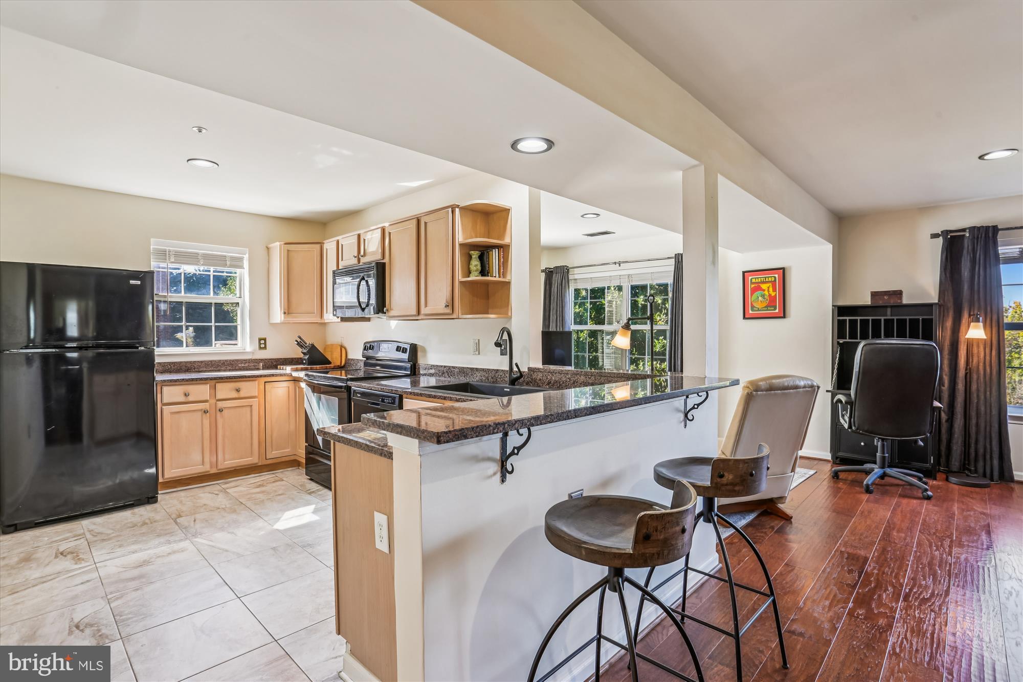 302 Ridgepoint Place, Unit 16 Gaithersburg, MD 20878 - Photo 7 of 40 a kitchen with granite countertop a table chairs refrigerator and a sink