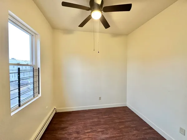 an empty room with fan and windows