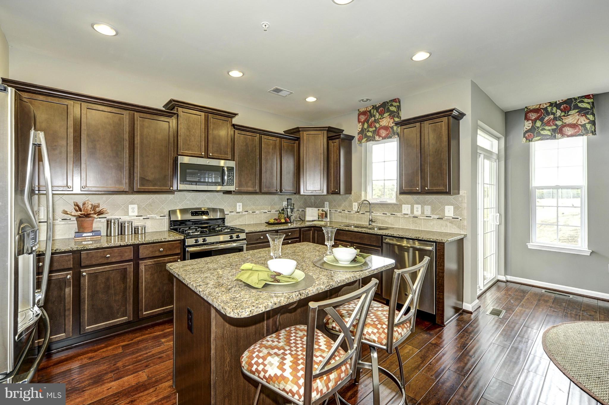 1003 Red Clover Road Gambrills, MD 21054 - Photo 2 of 30 a kitchen with stainless steel appliances granite countertop a stove top oven a sink dishwasher a dining table and chairs with wooden floor