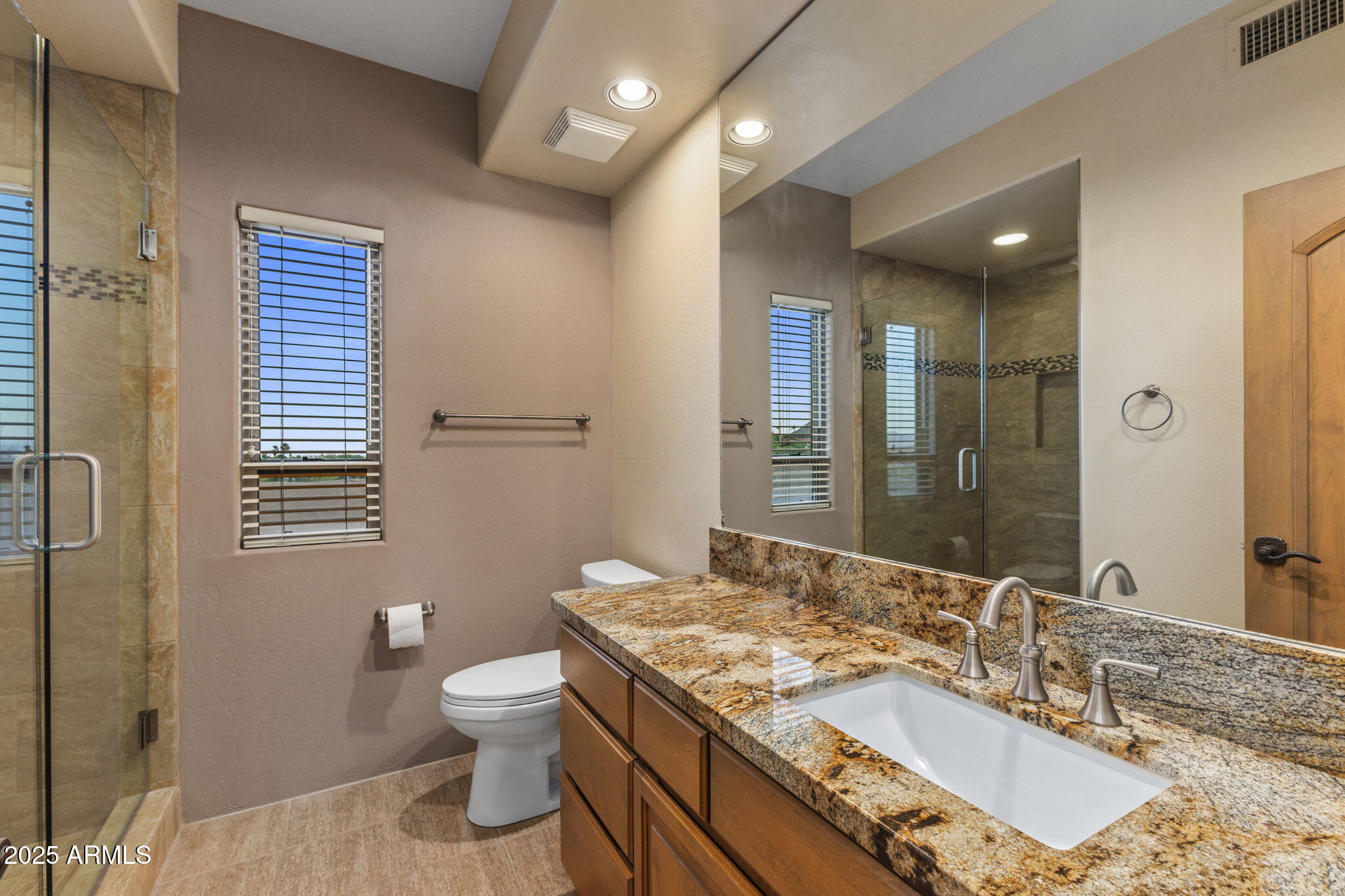 9247 North 24th Way Phoenix, AZ 85028 - Photo 78 of 99 a bathroom with a granite countertop sink a toilet a mirror and shower