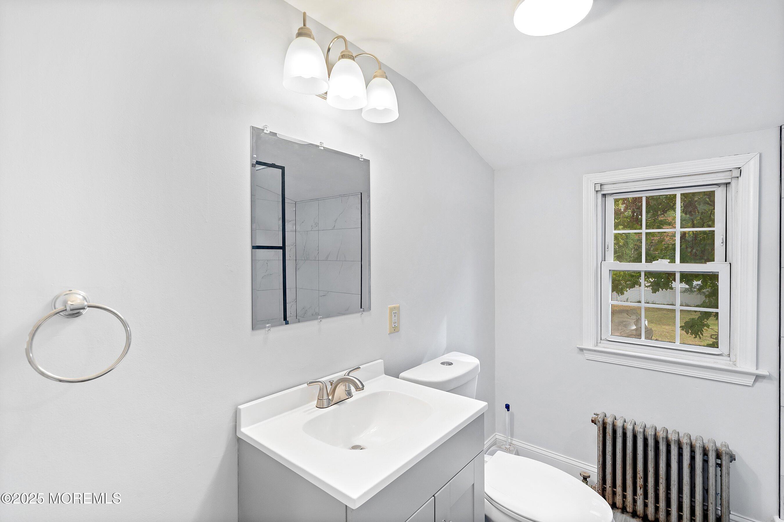 174 Alcoa Avenue Edison, NJ 08837 - Photo 14 of 20 a bathroom with a toilet a sink and mirror