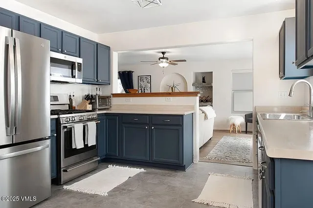 a kitchen with kitchen island granite countertop a sink stainless steel appliances and cabinets