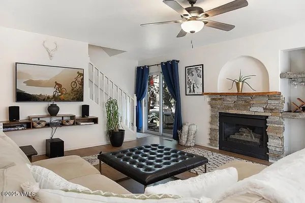 a living room with furniture a fireplace and kitchen view