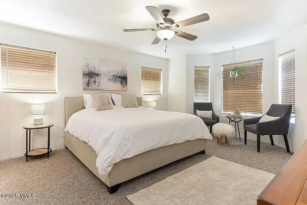 a bedroom with a large bed and windows